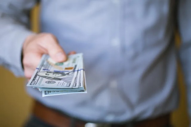 businessman holding money in his hands PK9P6X6 scaled 1