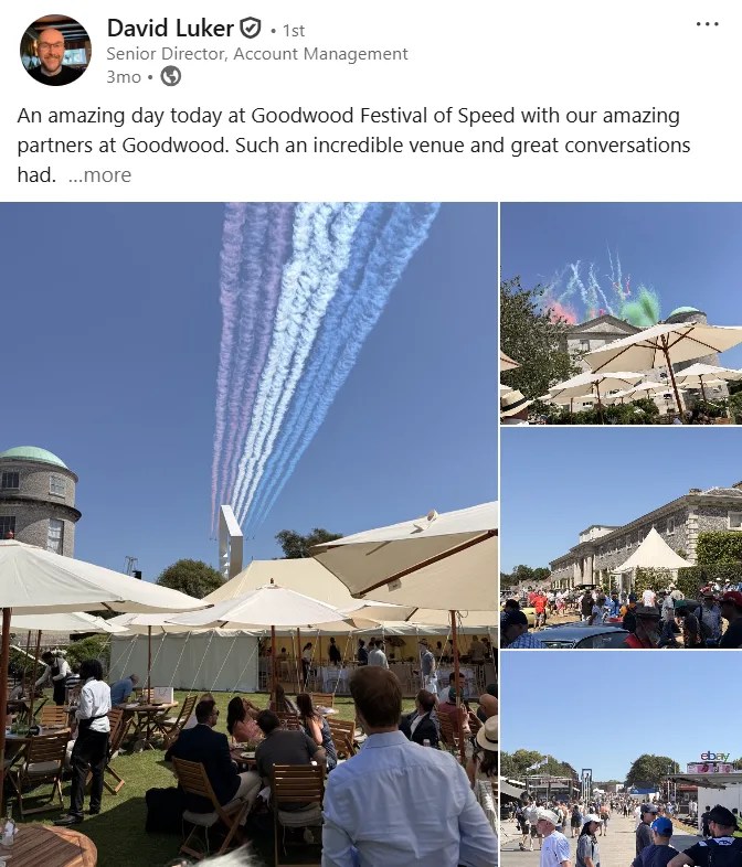 Red Arrows jet display leaving red, white, and blue smoke trails over the Goodwood Festival of Speed with outdoor hospitality tents and crowds.